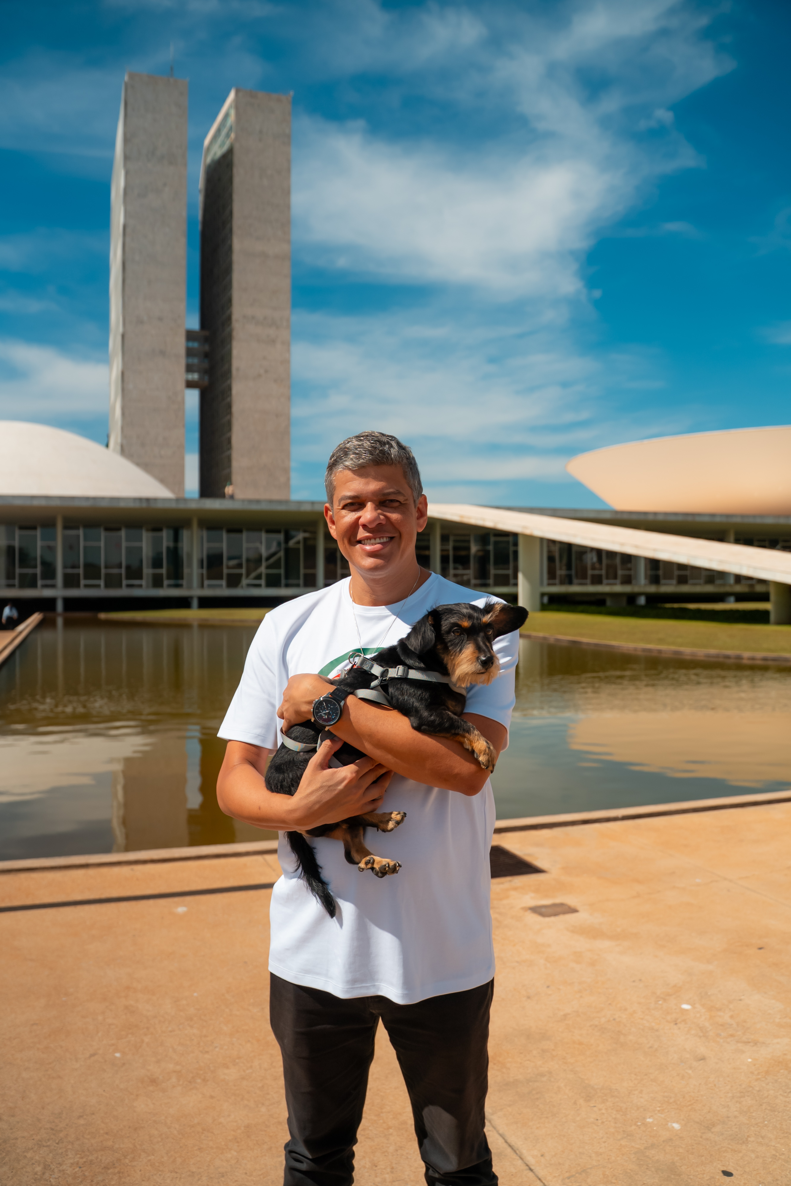 Daniel Donizet segurando um cachorro em frente ao Congresso Nacional